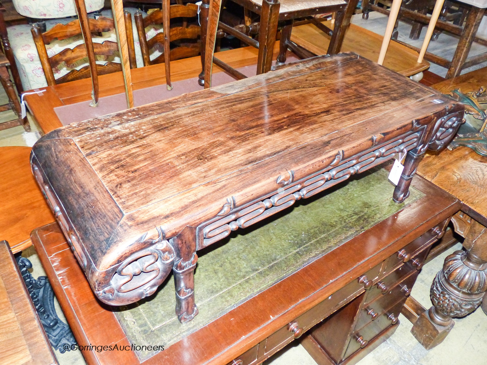 A Chinese carved hardwood low occasional table. W-110, D-44, H-32cm.